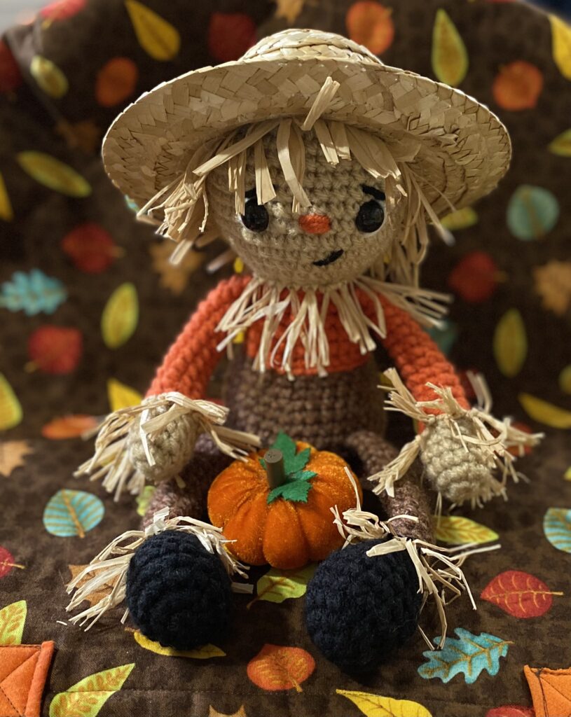 scarecrow crochet pattern with straw hat and raffia
